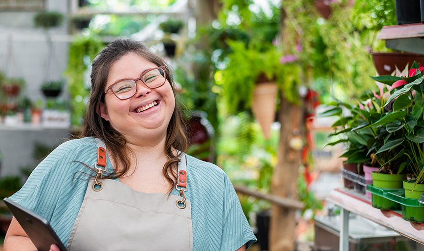 Eine junge Frau hat mit MiJob eine Arbeit in einem Blumengeschäft bekommen.