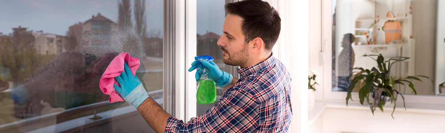 In der Teilqualifizierung zum Gebäudereinigungshelfer lernt ein junger Mann Fenster putzen.