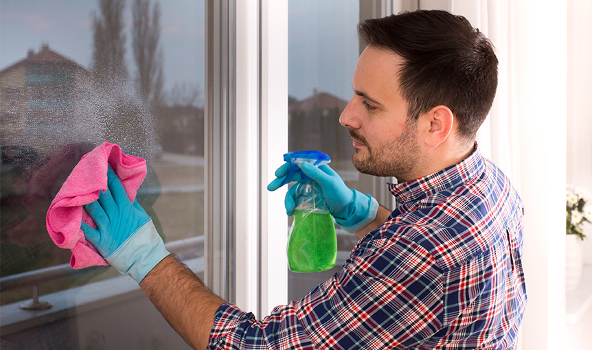 In der Teilqualifizierung zum Gebäudereinigungshelfer lernt ein junger Mann Fenster putzen.