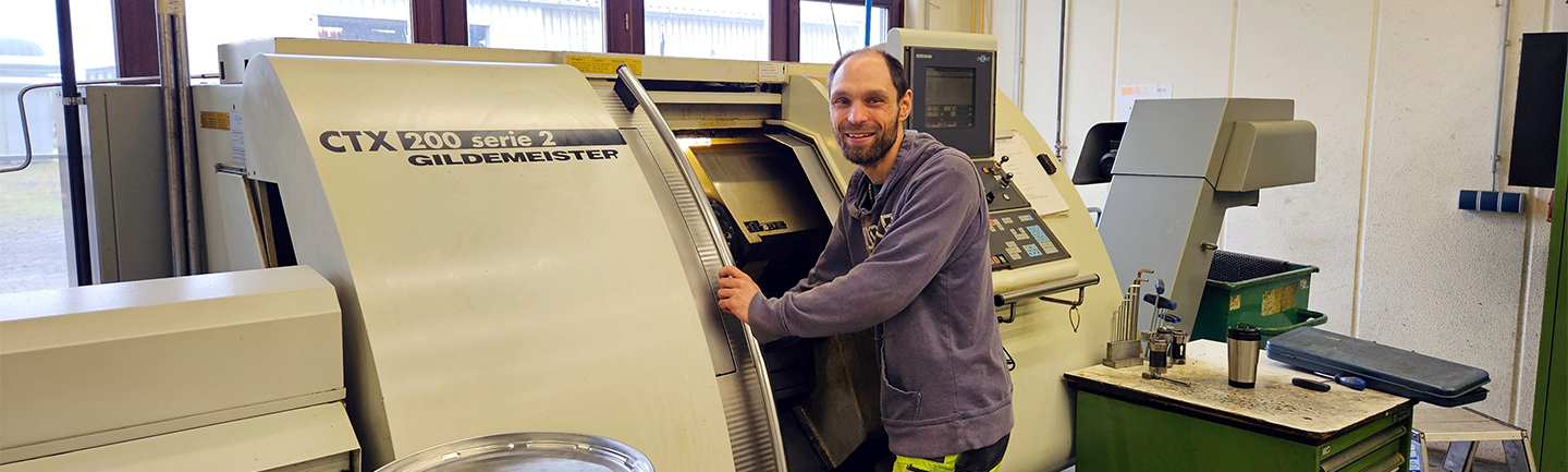 Ein Mann bedient in der CNC-Metallbearbeitung eine Maschine.