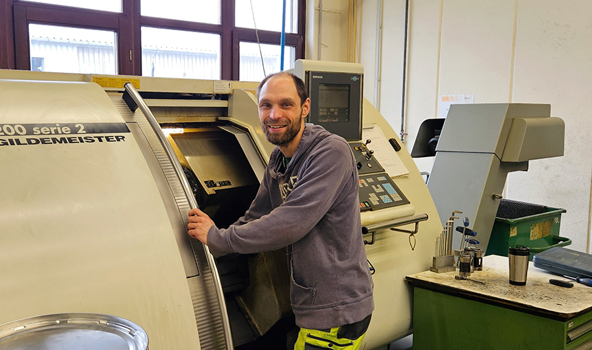 Ein Mann bedient in der CNC-Metallbearbeitung eine Maschine.