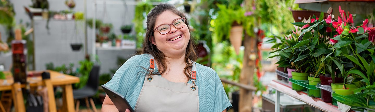 Eine junge Frau hat mit MiJob eine Arbeit in einem Blumengeschäft bekommen.