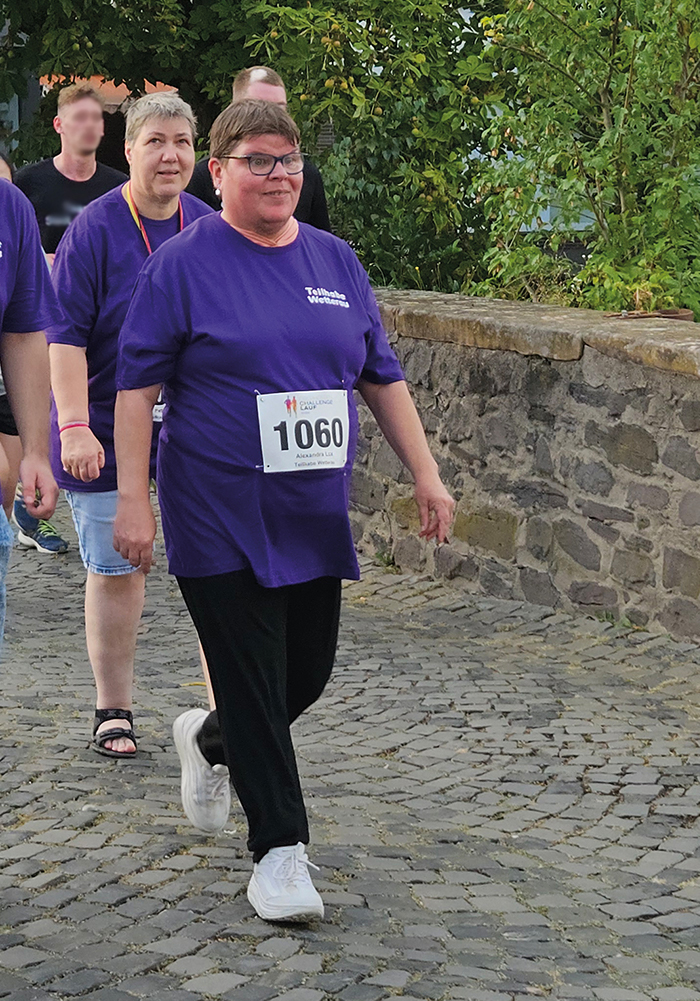 Zwei Frauen in lila T-Shirts laufen beim OCL in Nidda über eine Brücke.