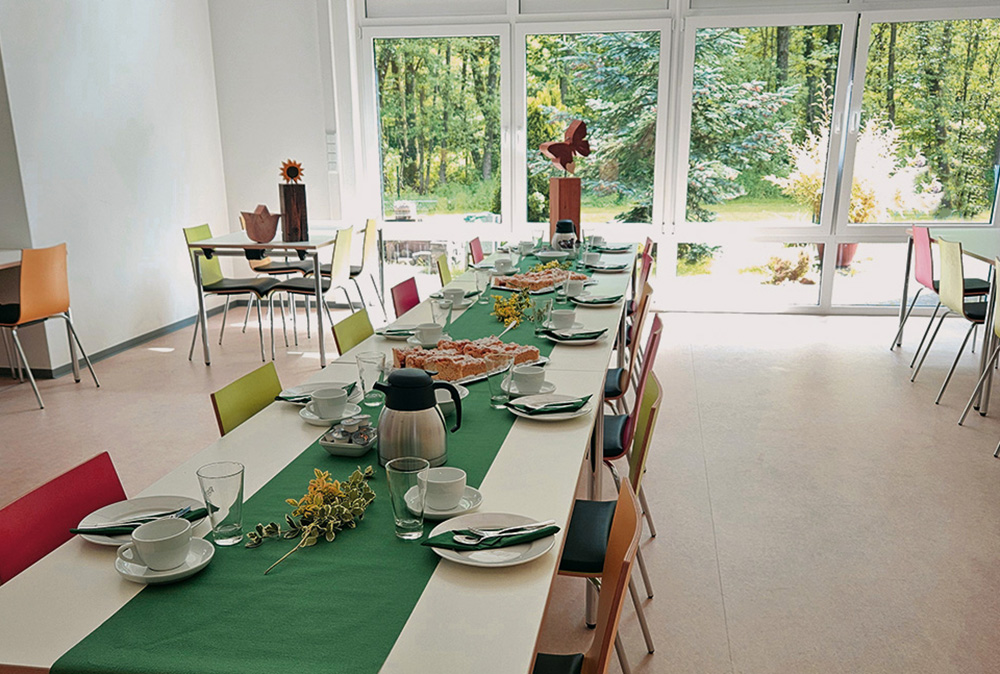 Für das Trösterkaffee ist der Speisesaal eingedeckt: Auf den Tischen stehen Teller, Tassen, Gläser und Kuchen.