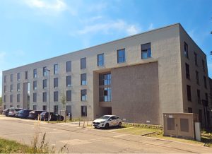 Mehrstöckiges, modernes Wohngebäude mit vielen Fenstern und Flachdach